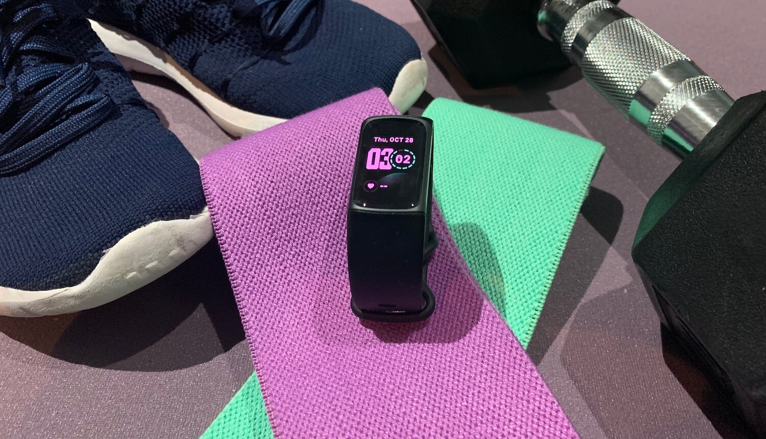 Fitbit Charge 5 with workout equipment.