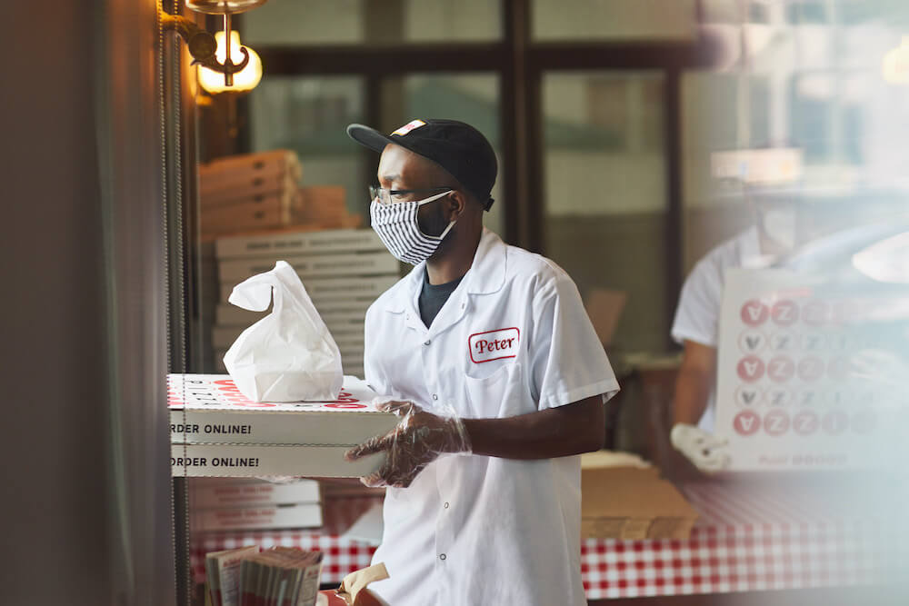 Man delivering pizzas via Square Online Doordash on demand delivery