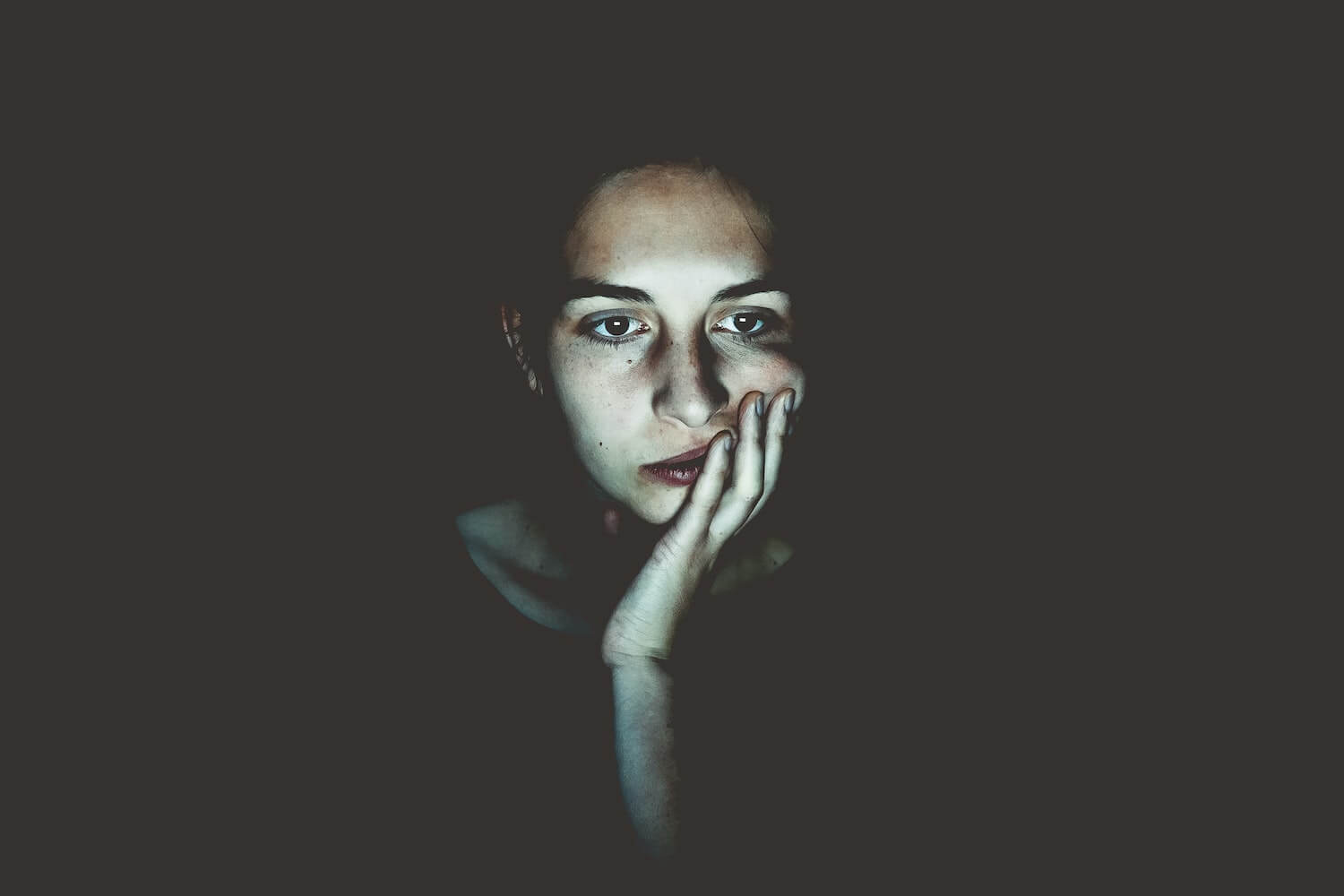 woman staring at a screen in the dark