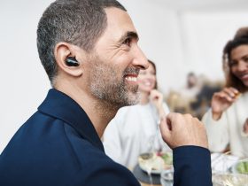 Man wearing the Sennheiser Conversation Clear Plus earbuds