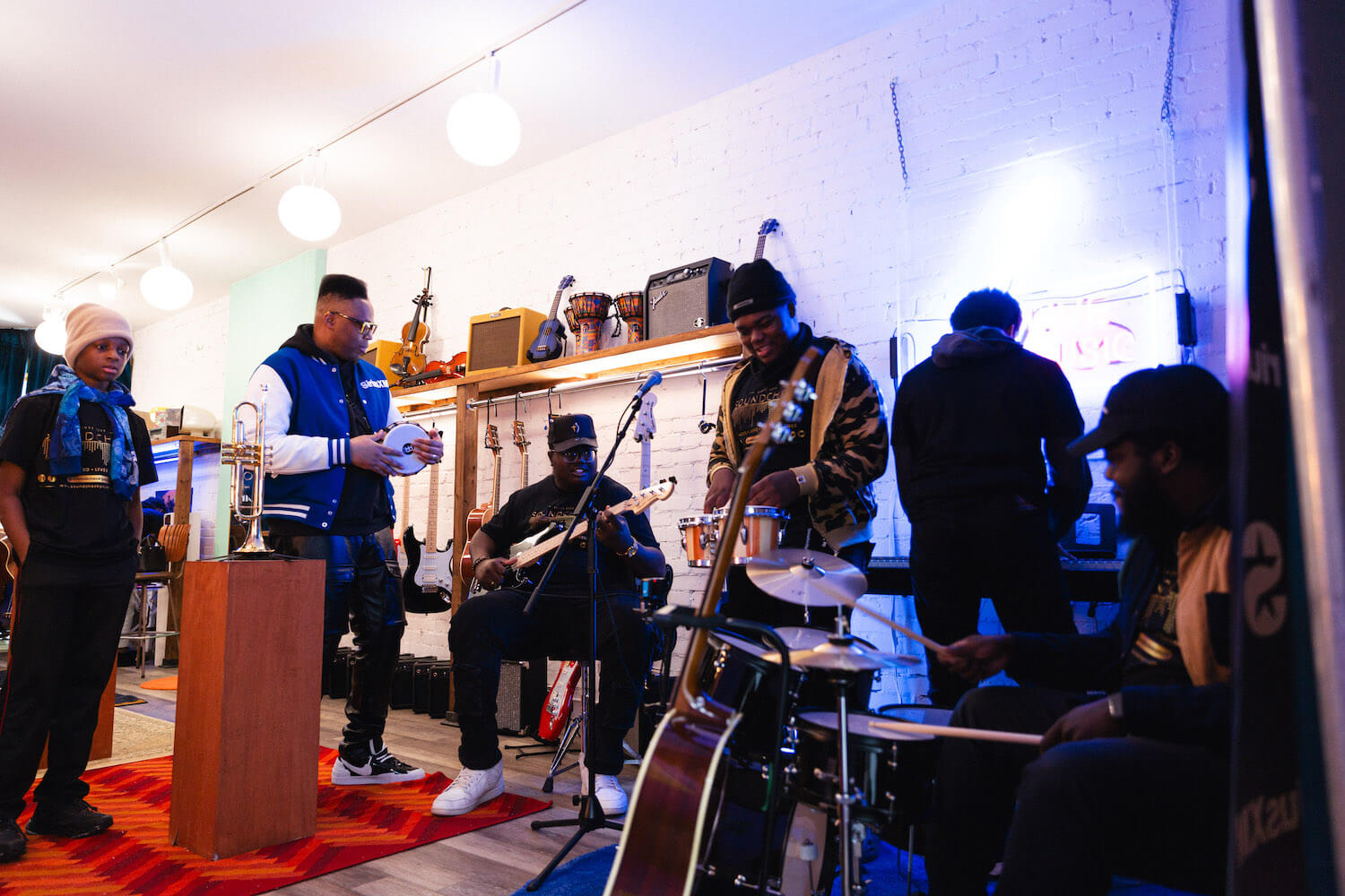 A group of people play musical instruments at the Soundwaves Music Store in Toronto.
