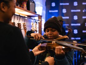 A child playing the violin at the SoundWaves Music Store