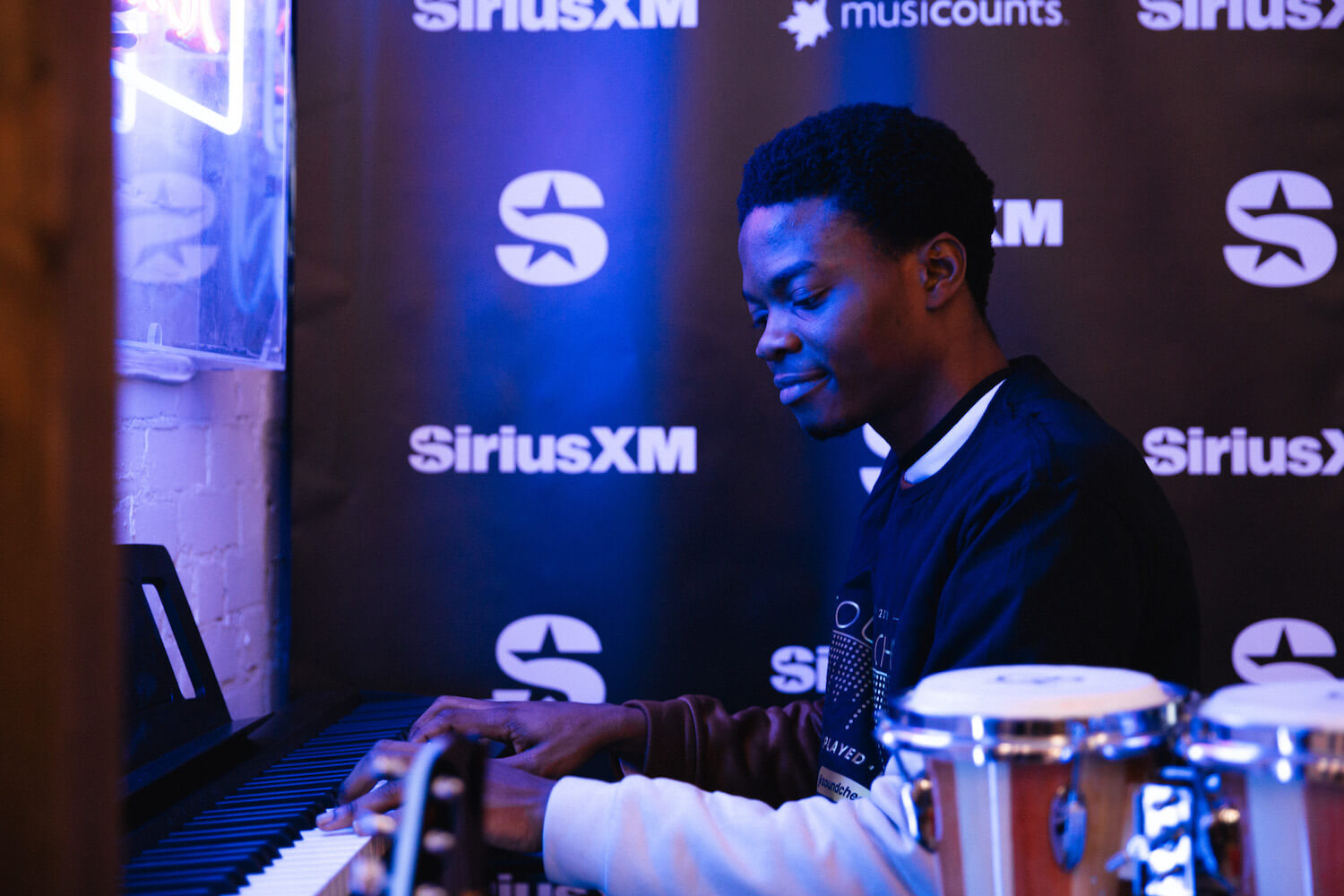 A young man playing the piano at the Soundwaves Music Store in Toronto.