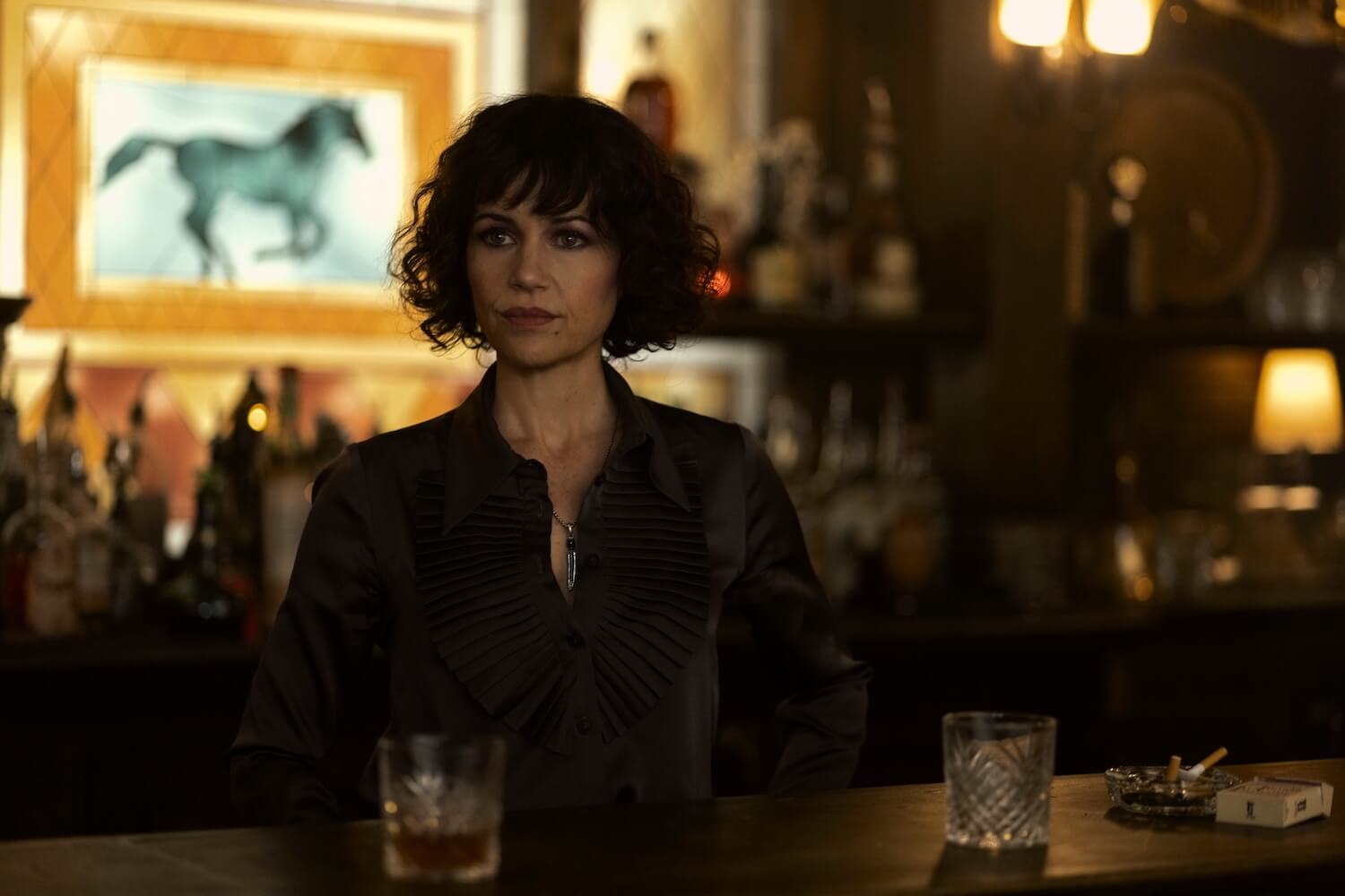 Verna standing behind a bar in a scene from The Fall of the House of Usher.
