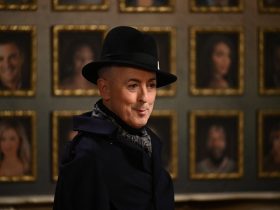 Alan Cumming wearing a black coat and hat in The Traitors.