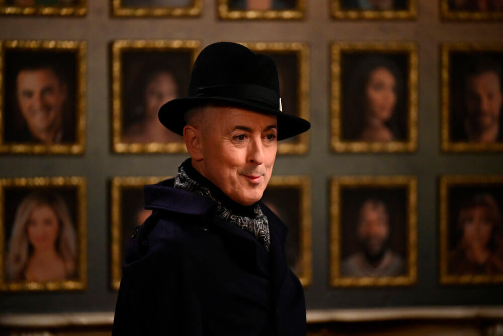 Alan Cumming wearing a black coat and hat in The Traitors.