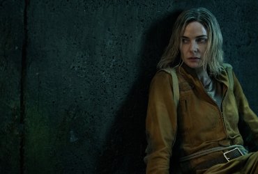 Juliette from Silo hiding around a corner