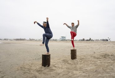 Daniel and Johnny both doing the crane pose on the beach in Cobra Kai.