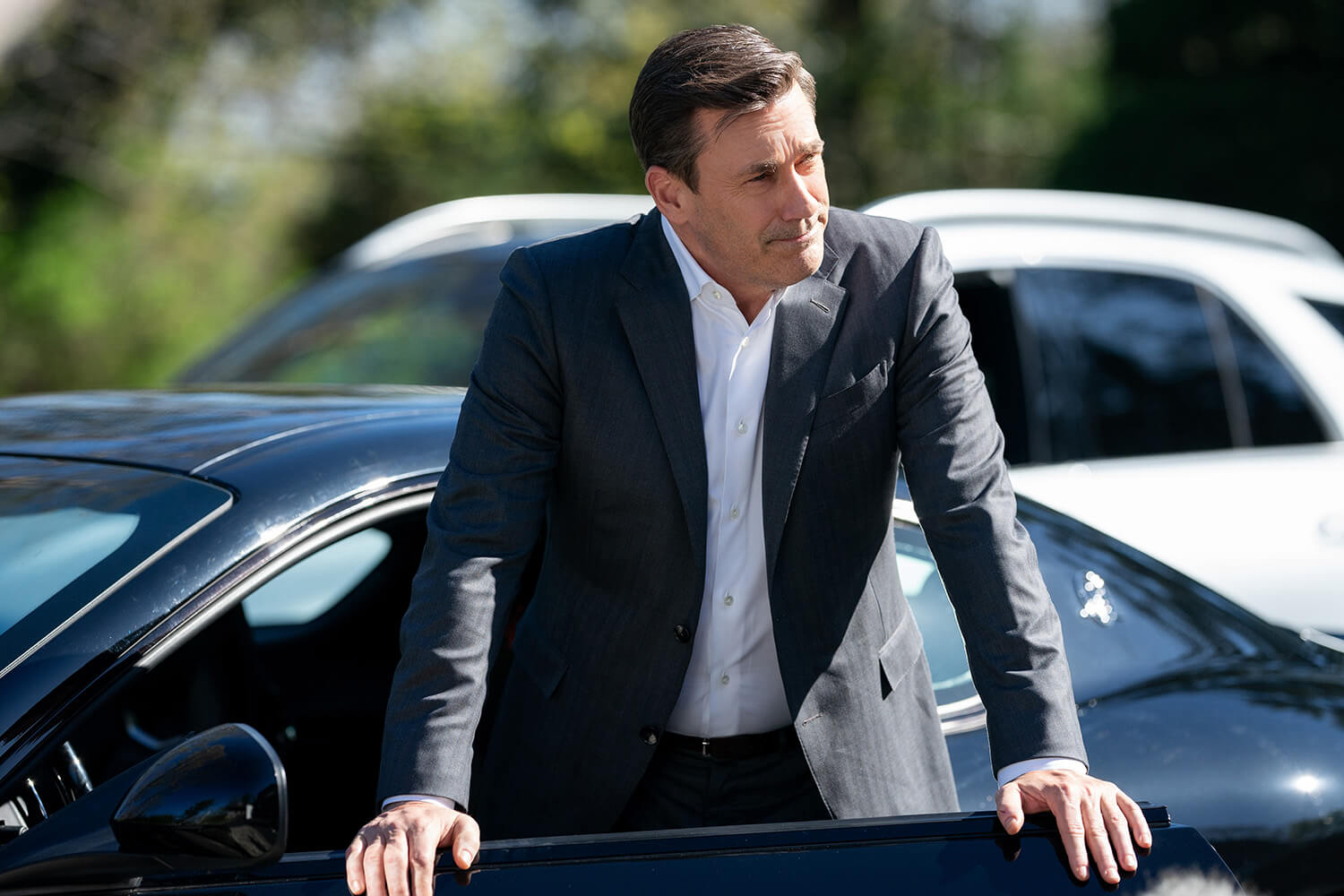 Jon Hamm standing by his car door in Your Friends and Neighbors.