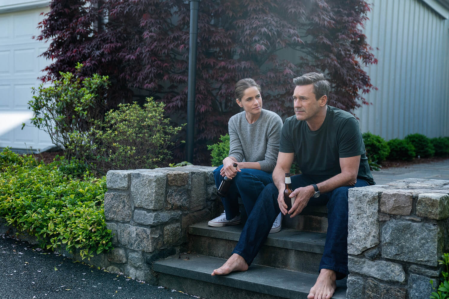 Coop and his wife sitting on the porch steps talking in Your Friends and Neighbors.