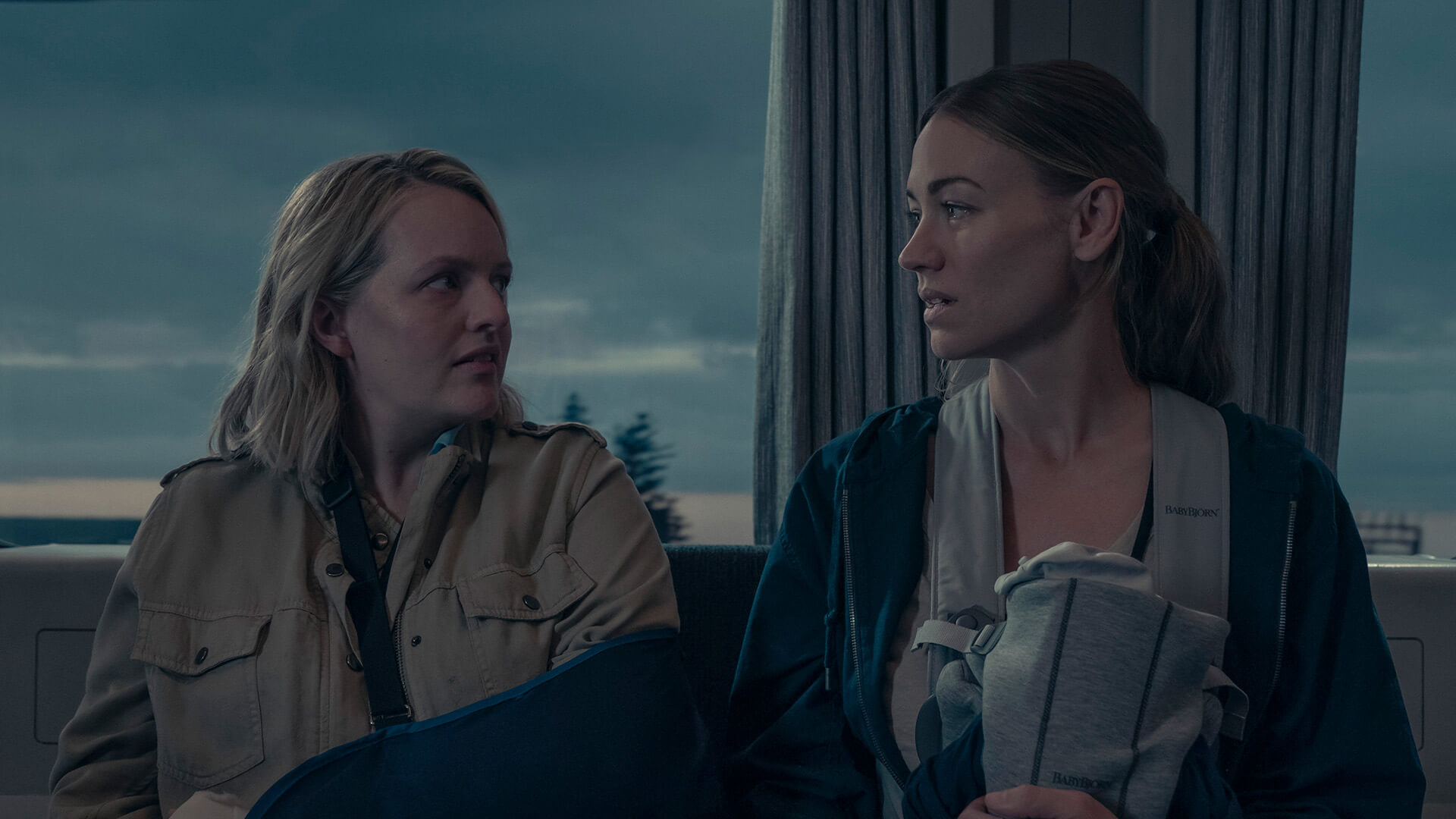 June and Serena looking at one another while holding their babies on a train in The Handmaid's Tale.