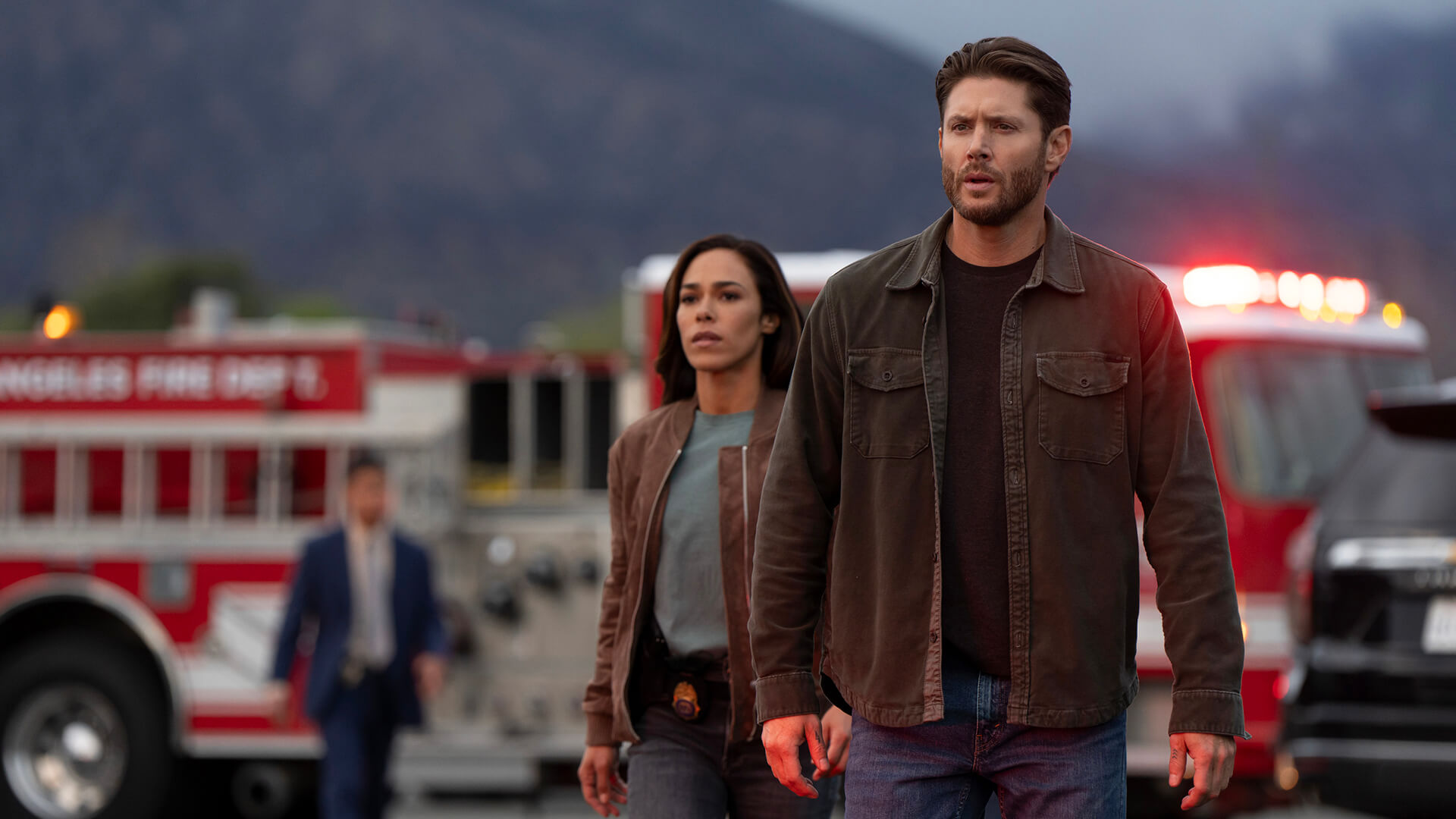 Mark and Amber stand in front of a fire truck in Countdown.