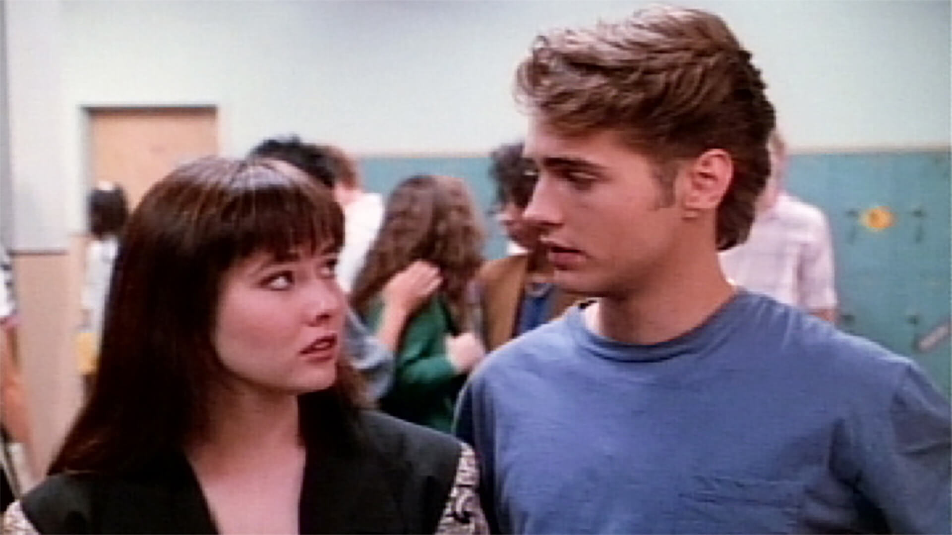 Brenda and Brandon looking at one another in Beverly Hills, 90210.