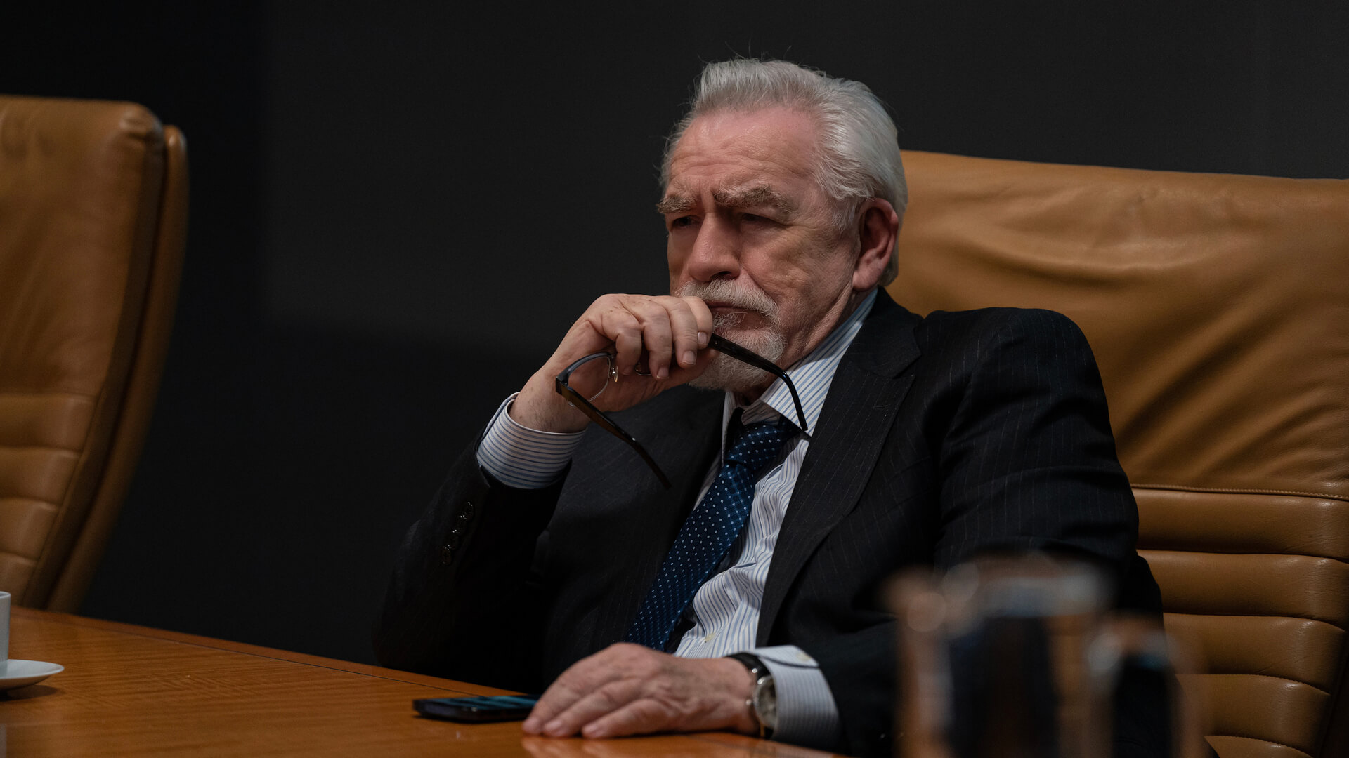 Logan Roy sitting at his desk in Succession.
