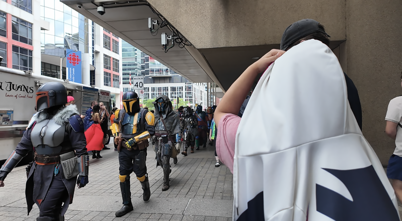 People in costume walking into Fan Expo Canada.