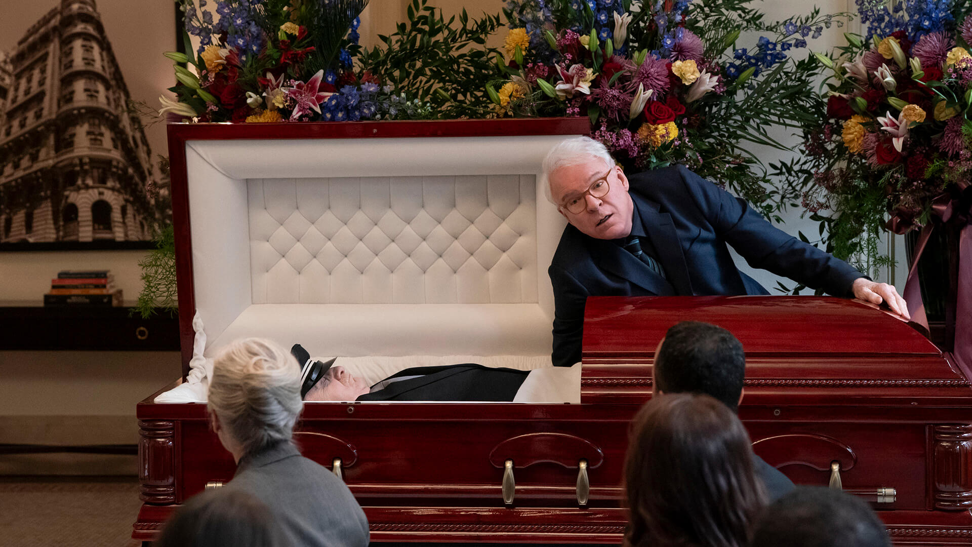 Charles with his hand in Lester's coffin in Only Murders in the Building.