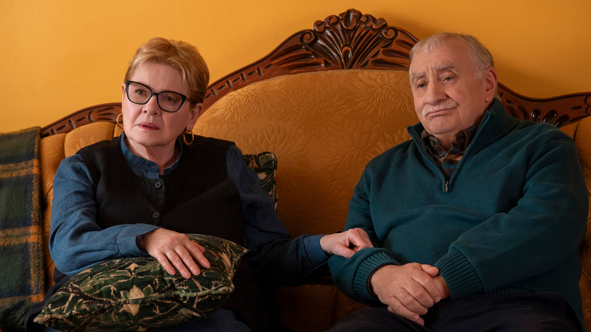 A woman and man sit on the bed together in Only Murders in the Building.