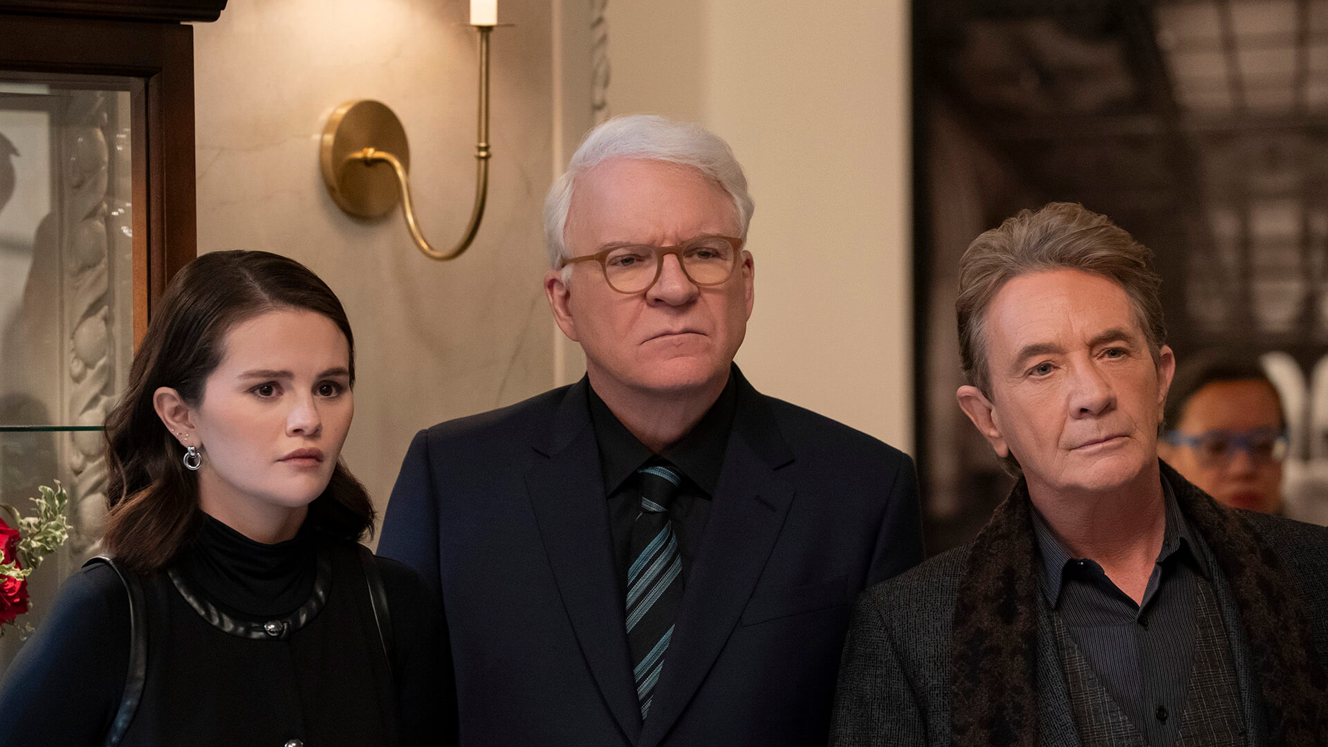 Mabel, Charles, and Oliver standing together in Only Murders in the Building.