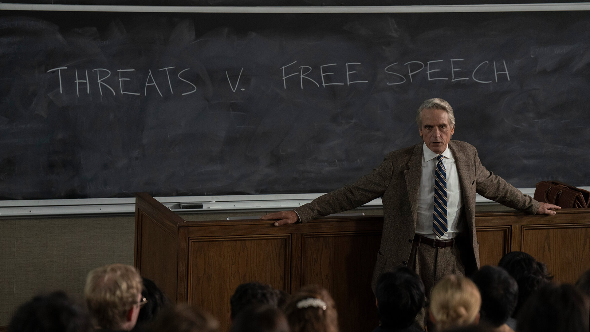 Alex's dad in class standing by the chalkboard in The Morning Show.