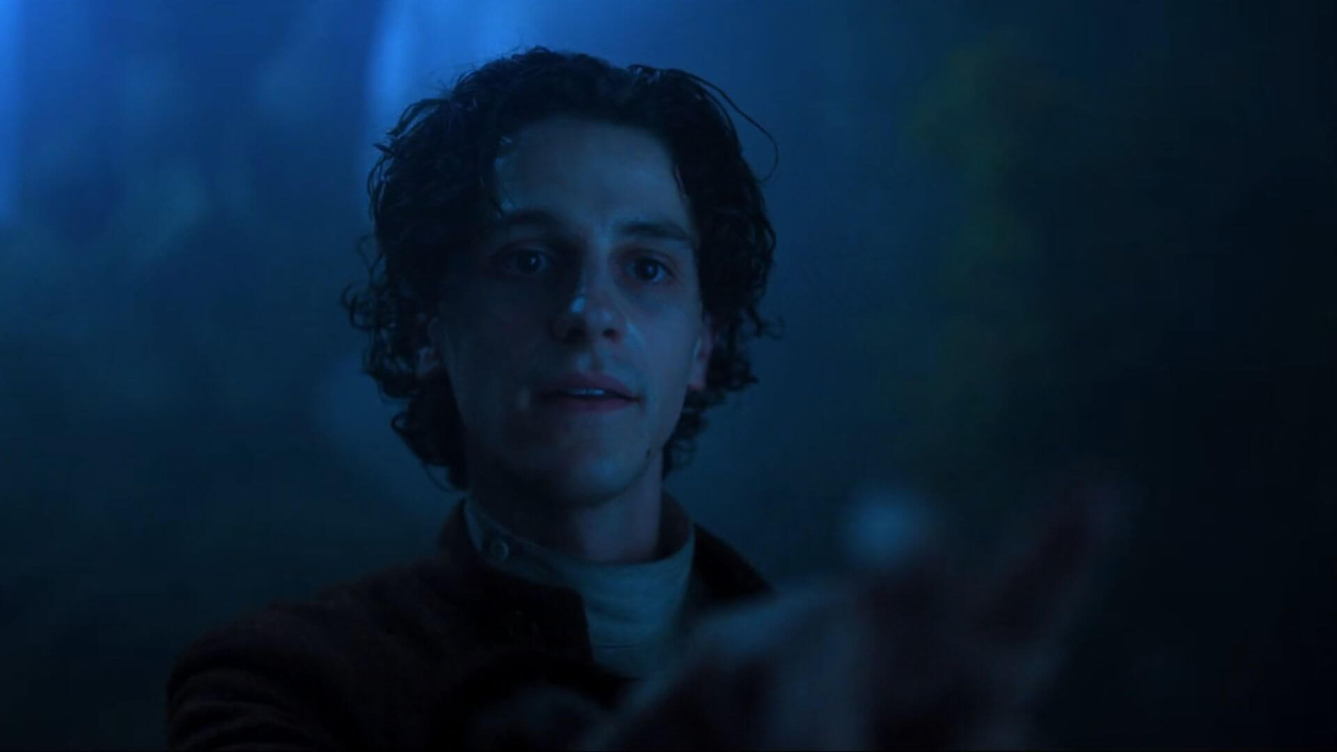 Isaac Night in the dark talking to someone in Wednesday.