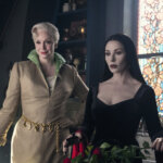 Larissa and Morticia standing together in Wednesday.