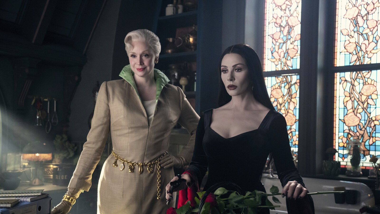 Larissa and Morticia standing together in Wednesday.