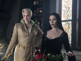 Larissa and Morticia standing together in Wednesday.