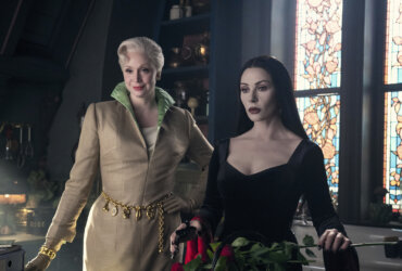 Larissa and Morticia standing together in Wednesday.