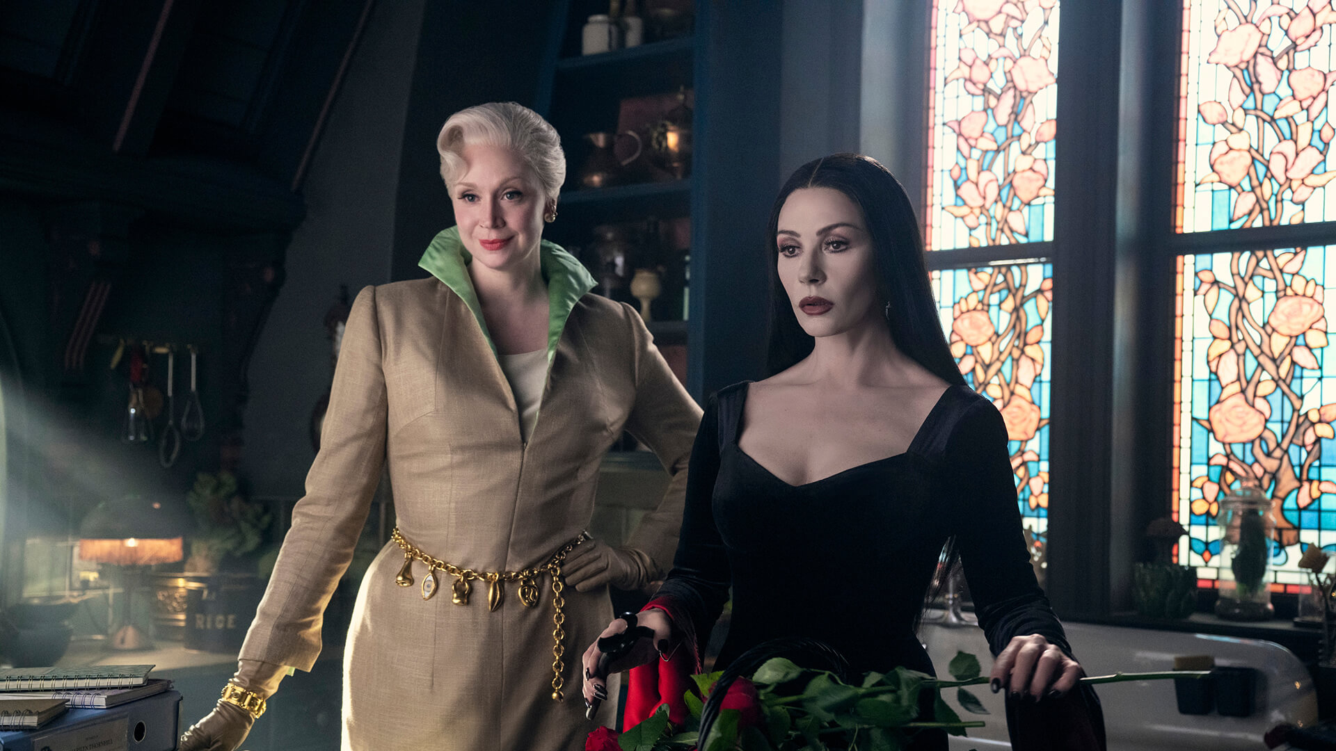 Larissa and Morticia standing together in Wednesday.