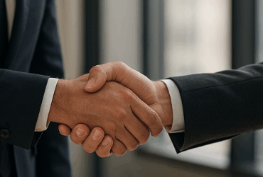 Two men in suits shaking hands.