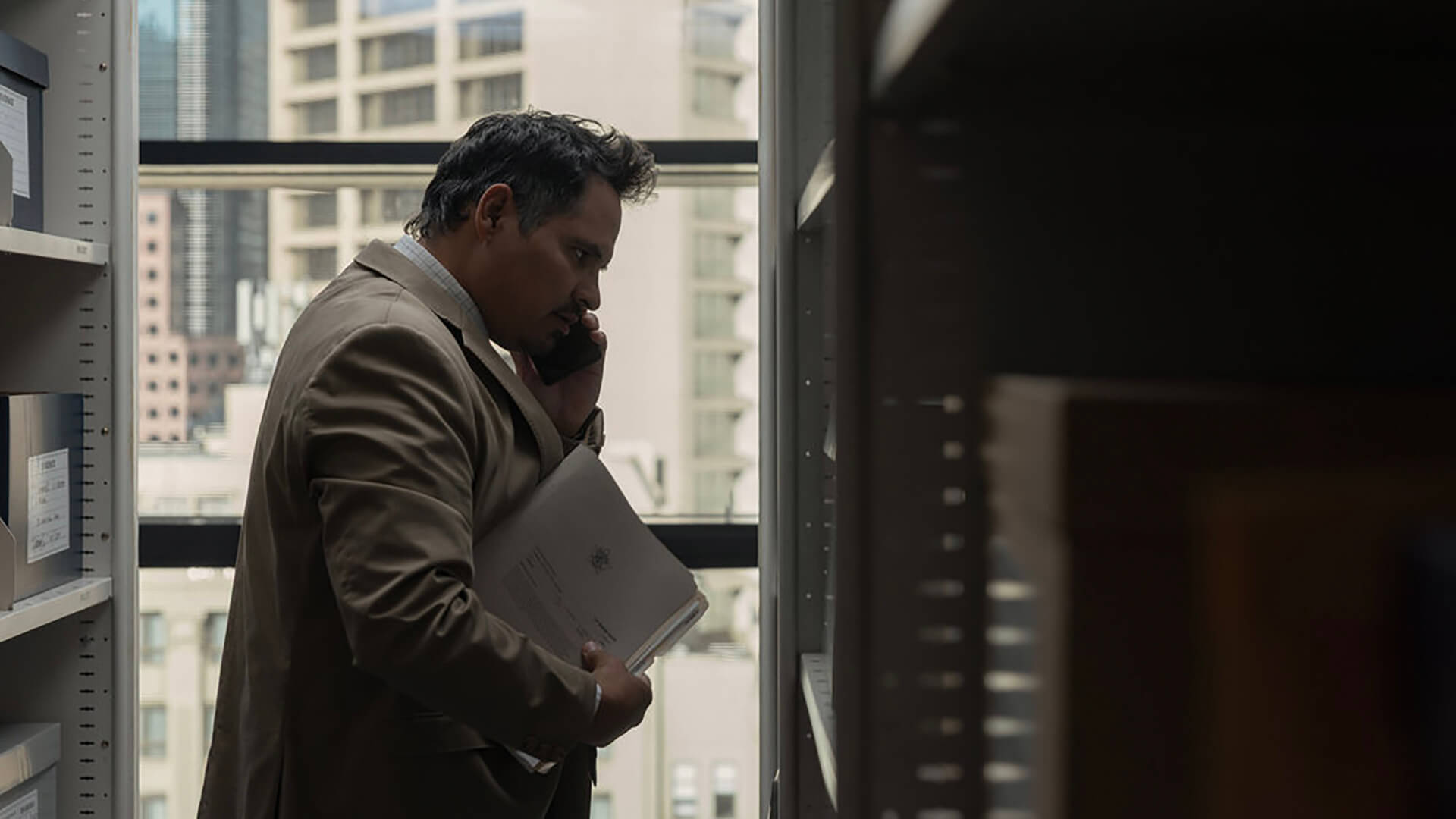 A police officer on the phone looking at files in All Her Fault.