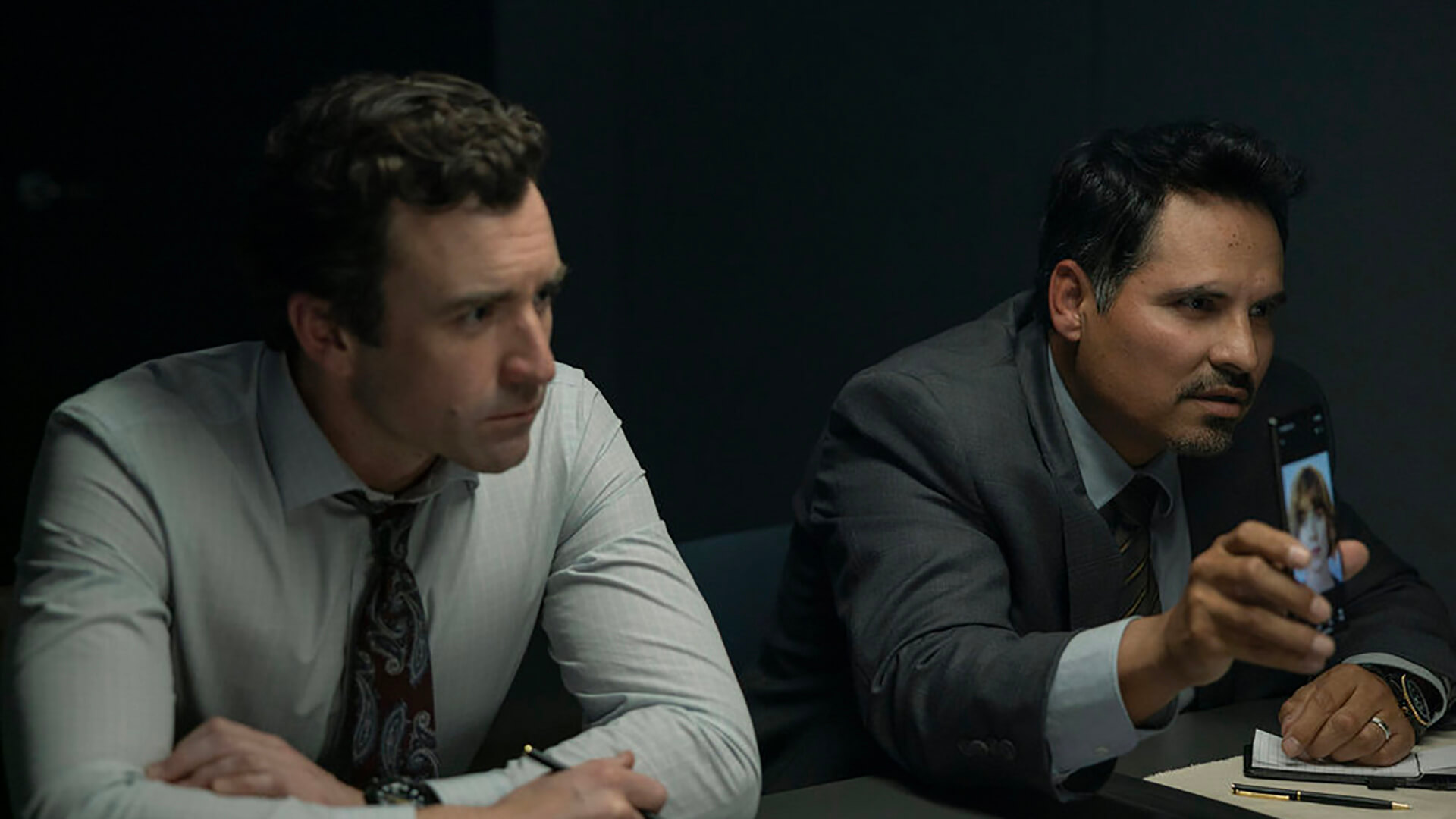 Two detectives showing a woman's photo to someone in All Her Fault.