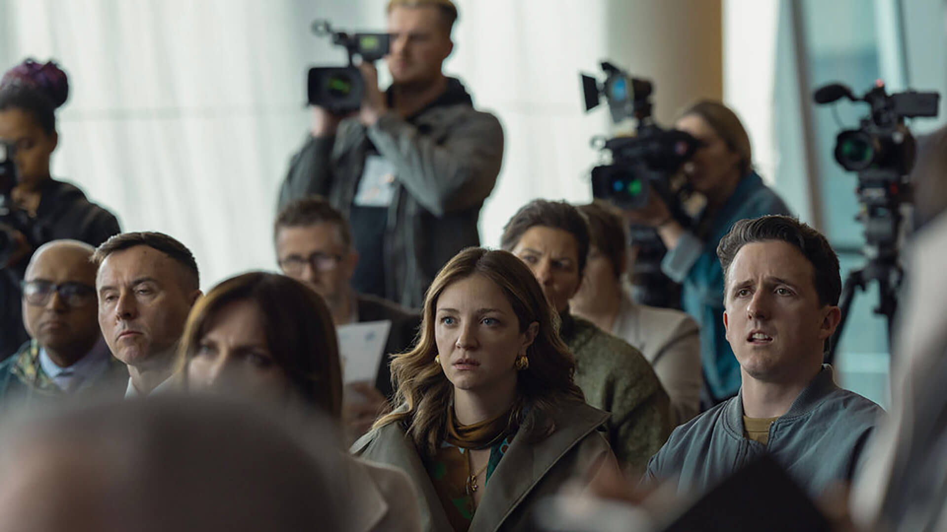The family sitting at a press conference in All Her Fault.