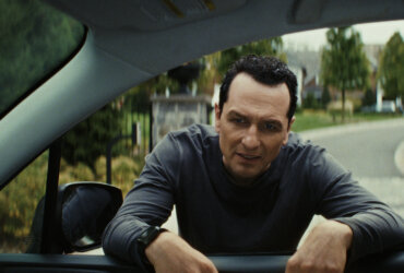 Nile standing at Aggie's car window in The Beast in Me.