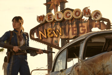 Lucy with a fun standing by the Las Vegas sign in Fallout.