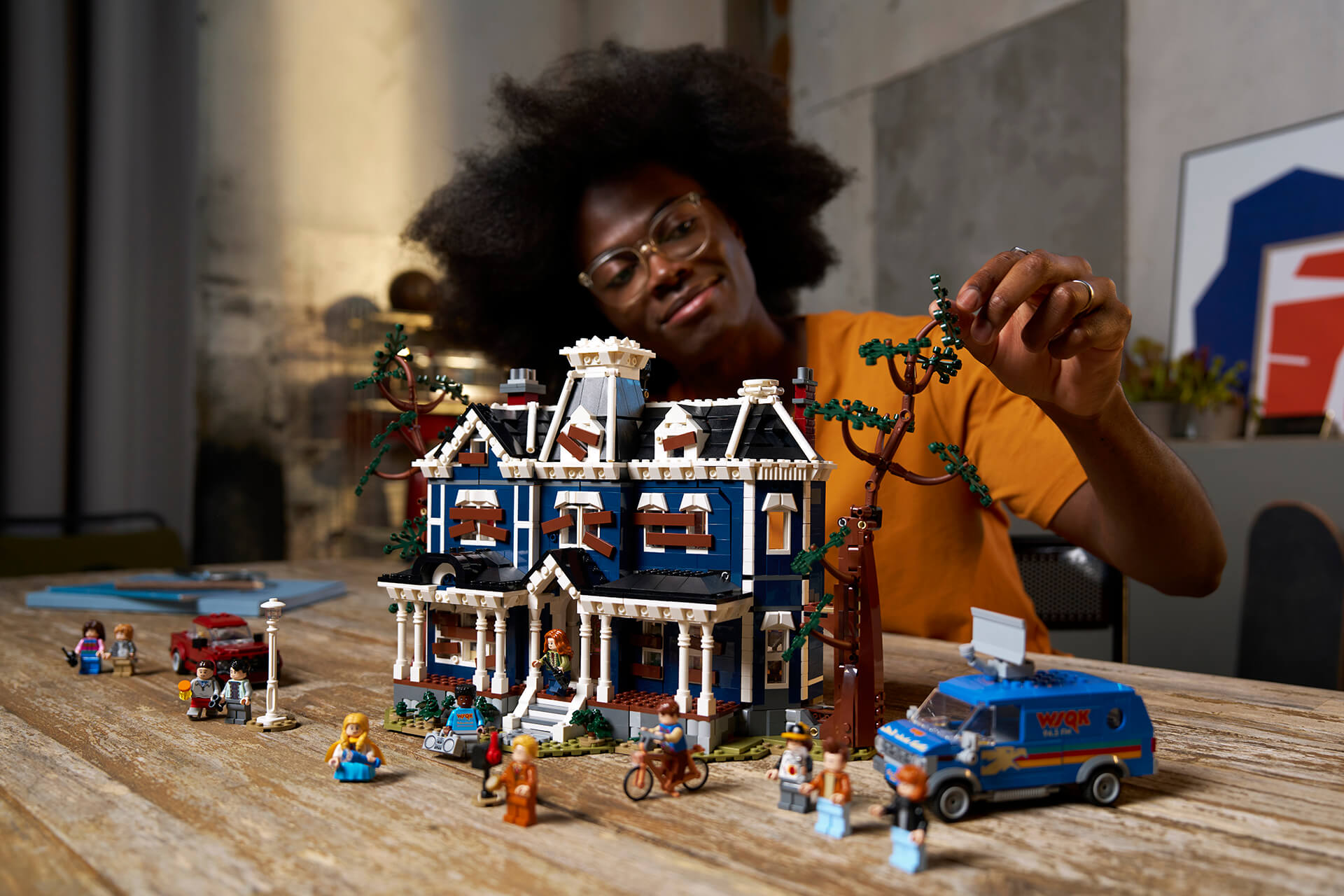 A man playing with the Lego Stranger Things: The Creel House set