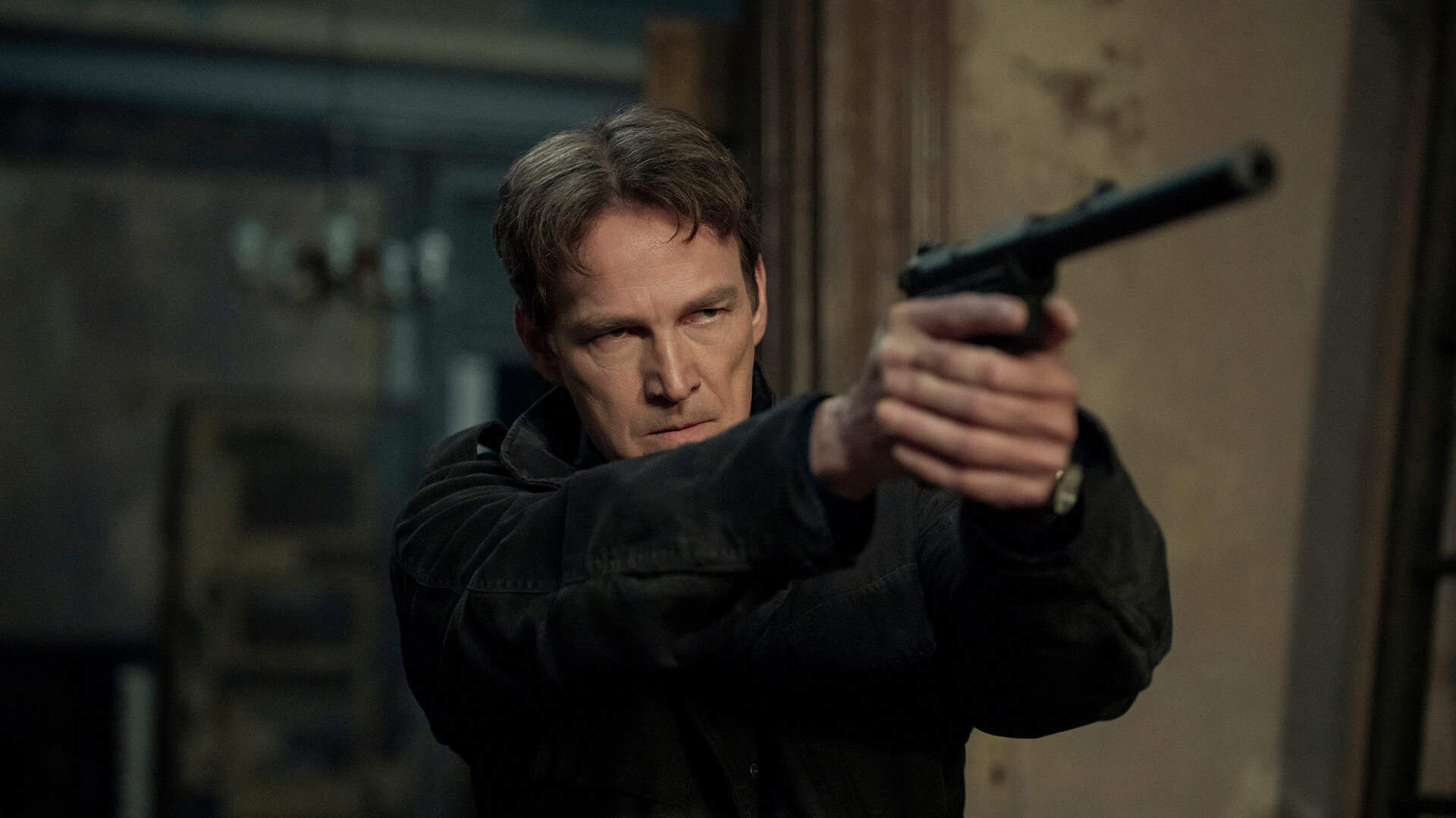 The Father holding out a gun in The Night Agent.