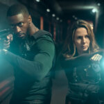 Alex and Kayla holding flashlights and a gun in Cross.