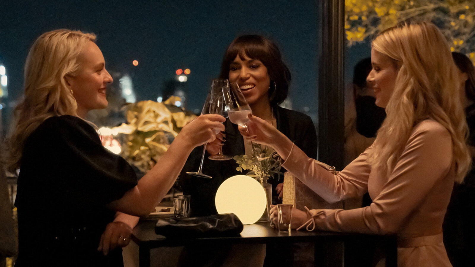 Three women clinking glasses on an outdoor patio in Imperfect Women.