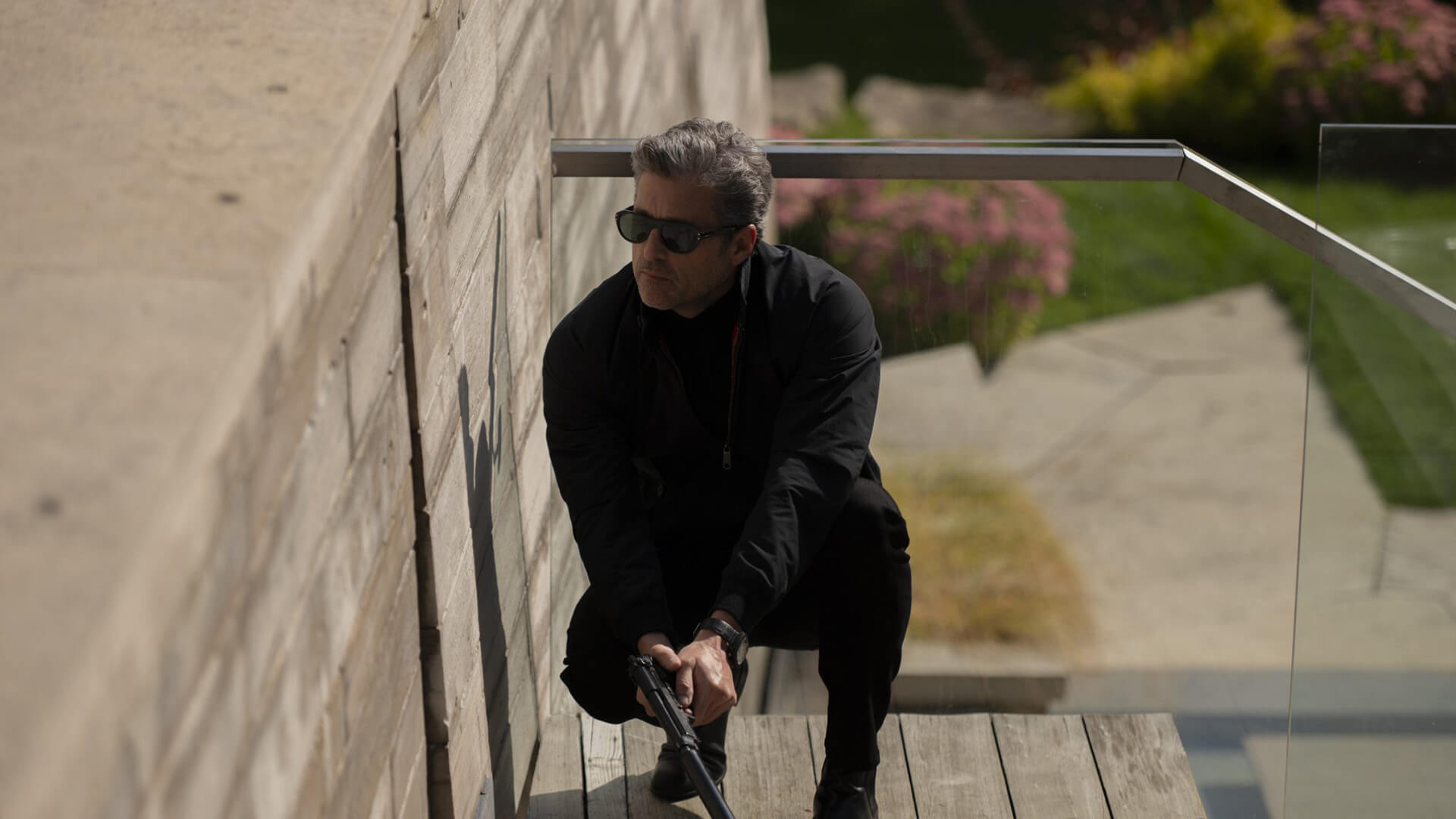 Angelo crouching down in a corner with a gun in Memory of a Killer.