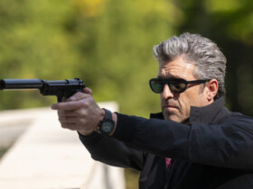 Angelo wearing sunglasses outside pointing a gun in Memory of a Killer.