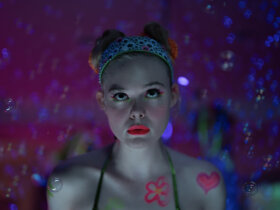 Margo in make-up o a psychadelic background in Margo's Got Money Troubles.