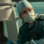 Kay with scrubs and a mask on in Scarpetta.