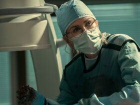 Kay with scrubs and a mask on in Scarpetta.