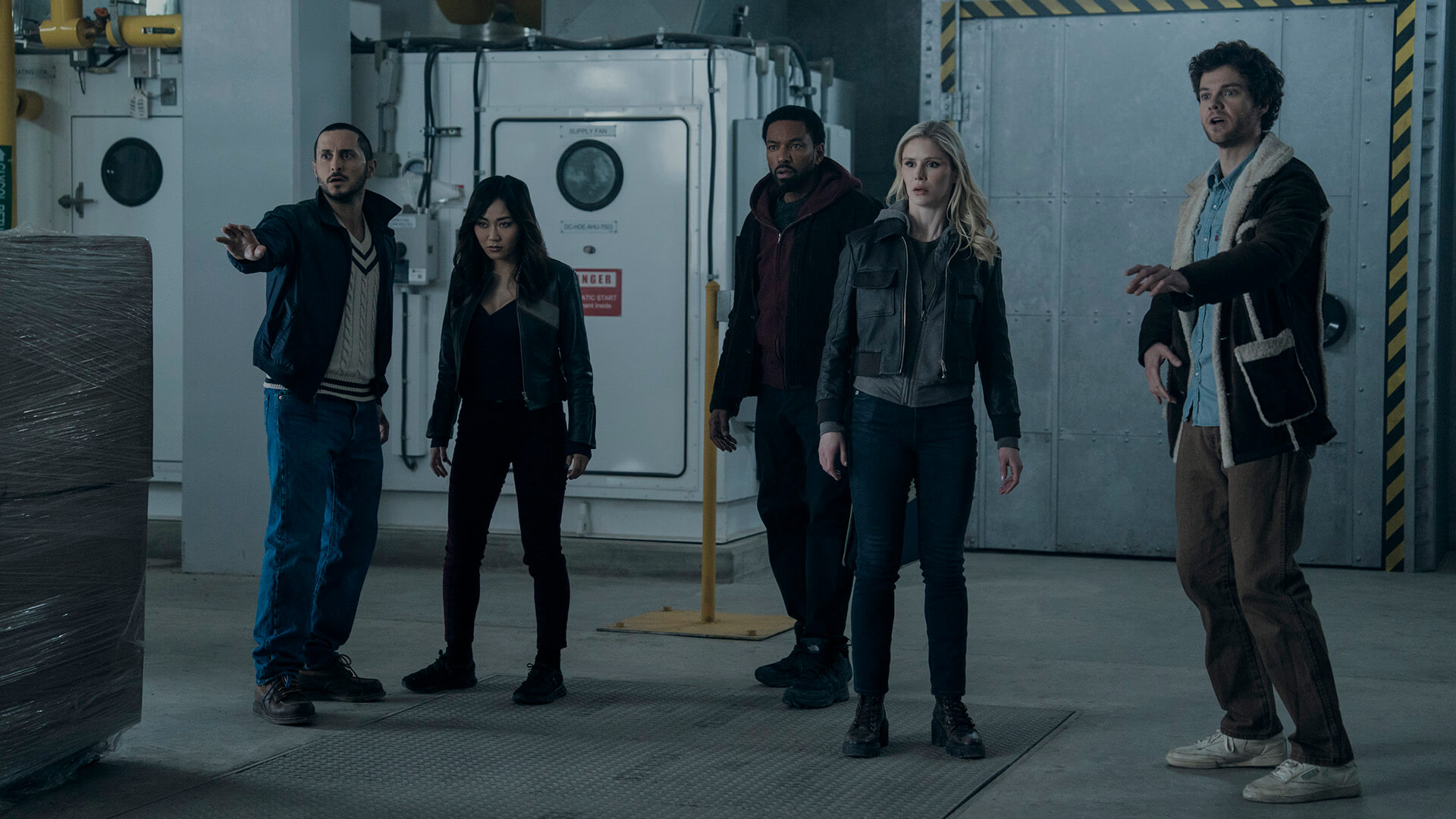 Members of The Boys standing in a warehouse.