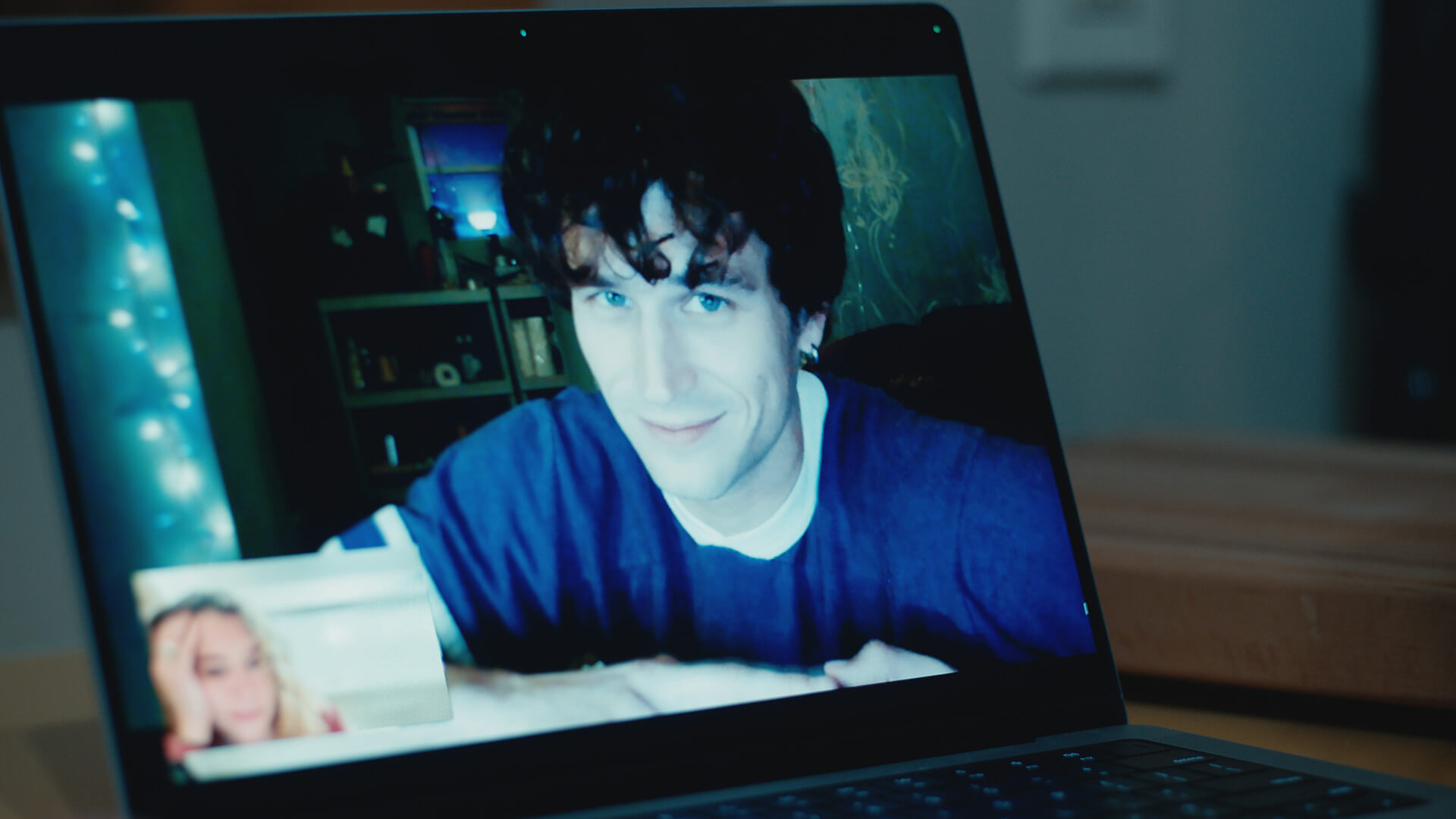 A young man smiling on a computer screen in Maximum Pleasure Guaranteed.