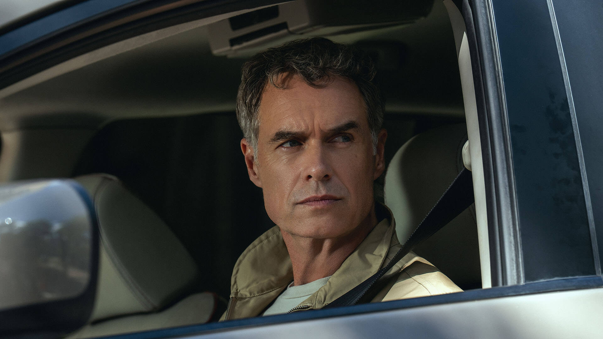Murray Bartlett sitting in a car glaring at someone in Maximum Pleasure Guaranteed.