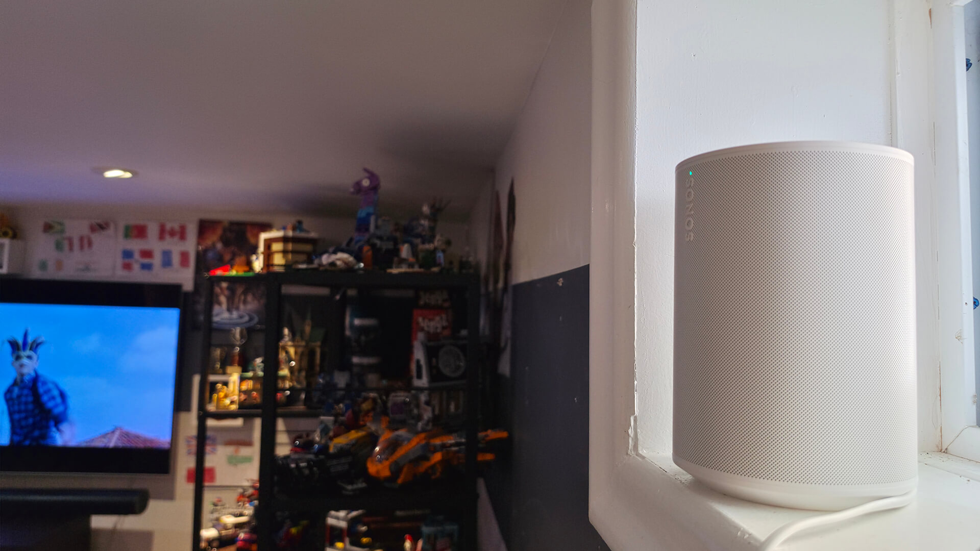 Sonos Era 100 on a windowsill behind a TV