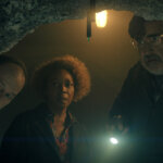 Wally, Judy, and Art looking into a cave in The Boroughs.