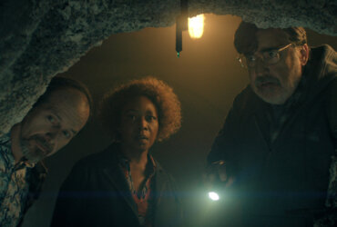 Wally, Judy, and Art looking into a cave in The Boroughs.